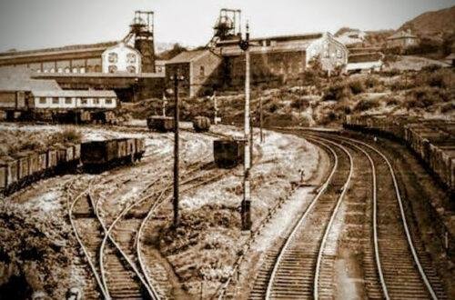 a view of A South Wales Valley Town After Coal Arrived 1900@, Th image shows a colliery and some new rail tracks where once there were sheep grazing
